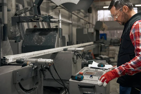 Mężczyzna Rękawiczkach Ochronnych Pracuje Maszynie Cięcia Profili Metalowych Fabryce — Zdjęcie stockowe