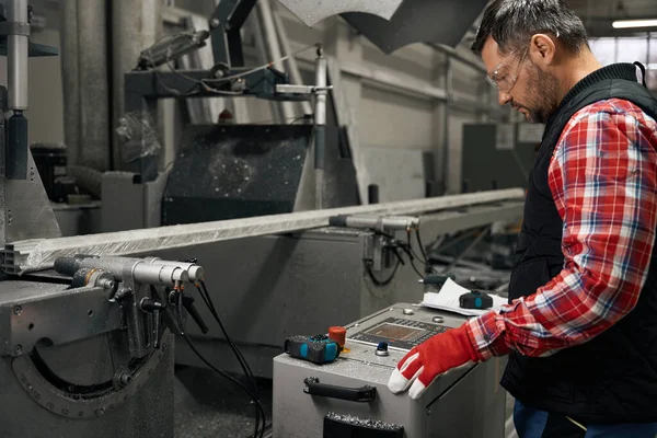 Mężczyzna Okularach Ochronnych Rękawiczkach Pracujących Maszynie Cięcia Profili Metalowych Fabryce — Zdjęcie stockowe