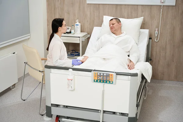 환자의 클리닉에서 전문의와 이야기를 나누면서 의료용 침대에 — 스톡 사진