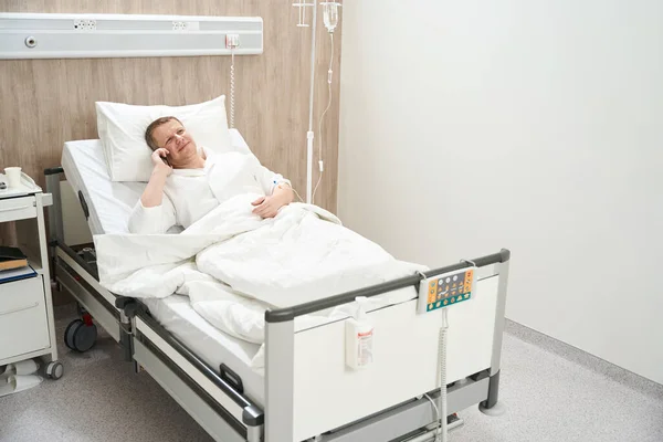 Полный Портрет Позитивного Храброго Пациента Мужчины Медицинской Кровати Разговаривает Друзьями — стоковое фото