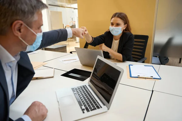 Pracownicy Ubraniach Biurowych Maskach Ochronnych Siedzący Przy Stole Laptopem Mówiący — Zdjęcie stockowe