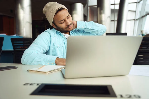 Mann Mit Hut Sitzt Computer Und Wärmt Sich Bei Arbeit — Stockfoto