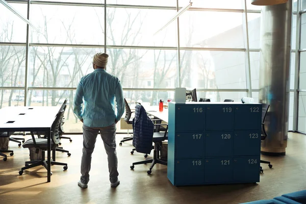 クローゼットの近くのオフィスに立っている青いシャツのプロの男 仕事の準備ができて — ストック写真