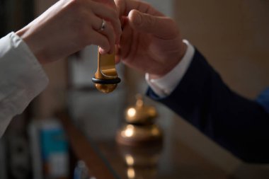 İş elbiseli bir adam resepsiyonun yanında duruyor, yönetici yanında duruyor ve anahtarları veriyor.