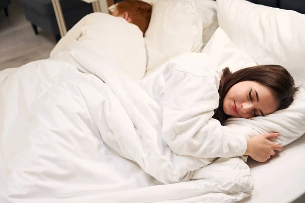 美しい若いカップルは 柔らかいホテルのベッドで甘く眠る 男たちは快適な部屋を借りる — ストック写真