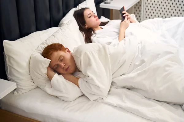 Tired Red Haired Guy Sleeps Soft Bed Next Him Lies — Stock Photo, Image
