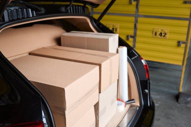 Depodaki arabanın bagajına doldurulmuş kutuların kesilmiş fotoğrafları.