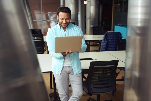 幸せな男性が机の近くに立ち ビジネスセンターでコンピュータに取り組んでいます — ストック写真
