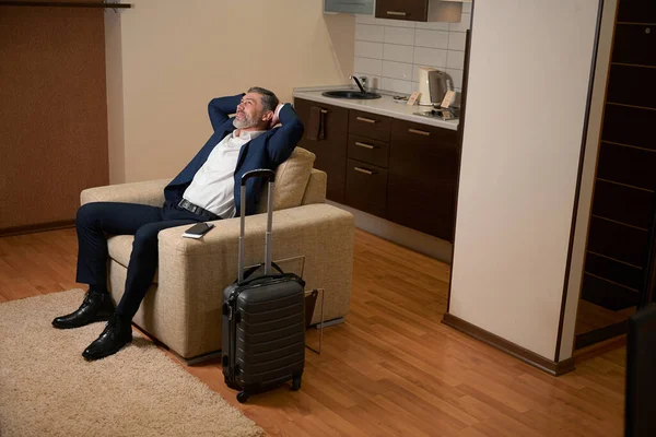 Smiling Man Office Suit Sitting Next Suitcase Hostel Room — Stock Photo, Image