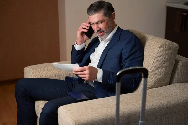 Elbisesi Içinde Gülümseyen Bir Erkek Telefonda Konuşuyor Oteldeki Kartvizitlere Bakıyor — Stok fotoğraf