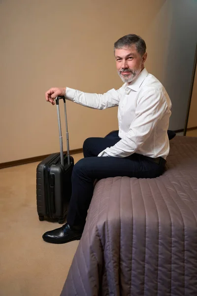Homem Sorridente Relaxando Sofá Segurando Alça Mala Hotel — Fotografia de Stock