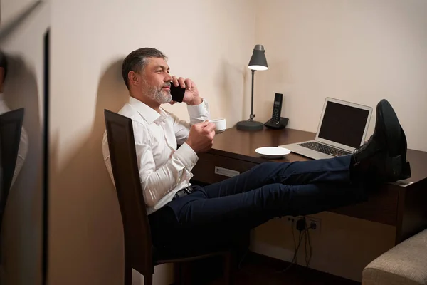 Vuxen Man Sitter Stol Framför Laptop Dricker Och Använder Smartphone — Stockfoto