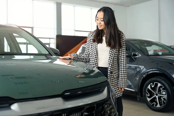 Young Woman Stands New Car She Strokes Shiny Hood — Stock Photo, Image