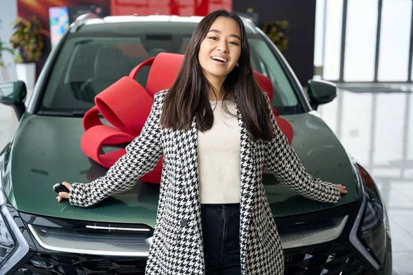 Genç Asyalı Bir Kadın Kırmızı Bir Hediye Yayıyla Arabanın Önünde — Stok fotoğraf