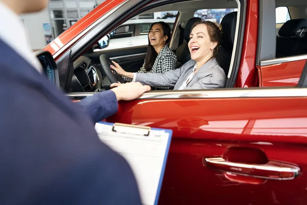 Kırmızı Otomobilde Koltukta Oturan Iki Gülen Bayan — Stok fotoğraf