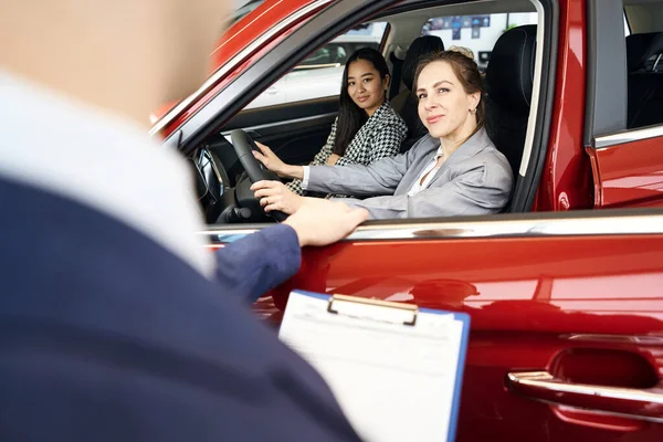 Kadını Kırmızı Arabada Oturmuş Yöneticiye Bakıyor — Stok fotoğraf