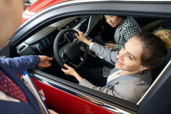 Two Happy Women Suits Looking Automobile Direct Gaze Person — Stock Photo, Image