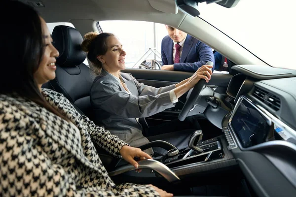 Neşeli Bayan Otomobilde Koltuklarda Oturuyor Gösterge Paneline Bakıyor — Stok fotoğraf