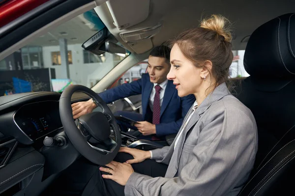 Adamı Ceketli Bir Kadına Arabanın Kontrol Panelini Gösteriyor — Stok fotoğraf
