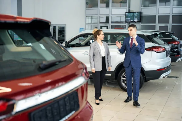 Happy Businessman Talking Woman Suit While Standing Red Car Autodealership — Stock Photo, Image