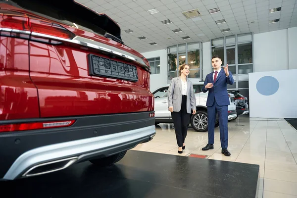 Happy Businessman Talking Woman Suit Standing Red Car Autodealership — Stock Photo, Image
