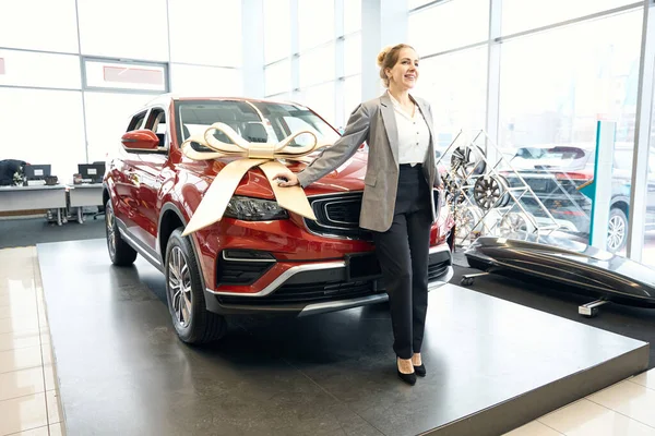 Leende Kvinna Kostym Står Framför Röd Bil Autodealership Och Håller — Stockfoto
