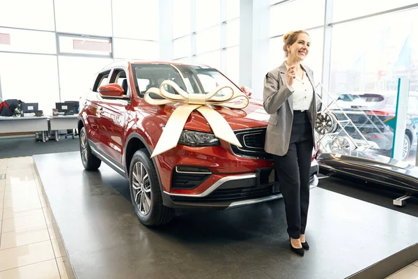 Gülümseyen Kadın Kırmızı Arabanın Önünde Dikiliyor Otomobil Galerisinde Carhood Yaslanıyor — Stok fotoğraf