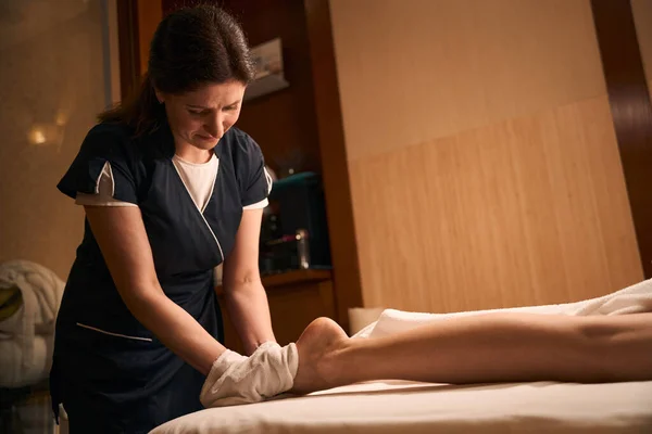 Skoncentrowany Biały Kobieta Klinika Kosmetyczna Masażysta Wycieranie Nogi Klienta Frotte — Zdjęcie stockowe