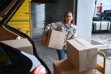 Depoda elinde bir kutuyla bekleyen güzel bir bayan.
