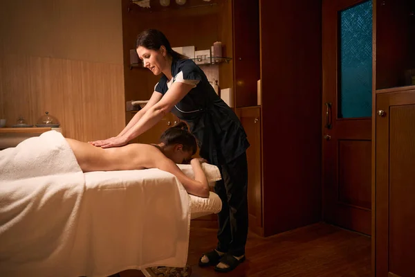 Focused Mature Masseuse Giving Lower Back Massage Wellness Center Female — Stock Photo, Image