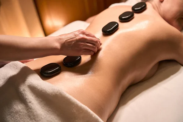 Zugeschnittenes Foto Der Hand Des Massagetherapeuten Die Heiße Basaltsteine Auf — Stockfoto