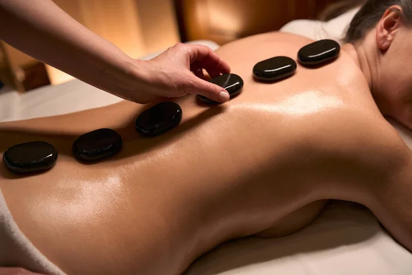 Cropped Photo Masseuse Hand Putting Hot Basalt Stones Adult Person — Stock Photo, Image