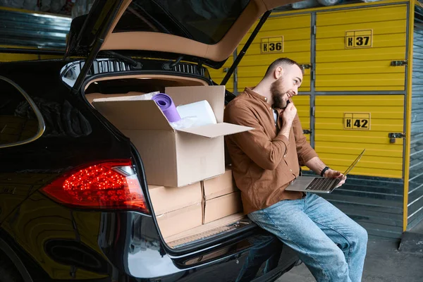 Grown Joyful Man Laptop Stands Trunk Boxes While Talking Phone — Stock Photo, Image