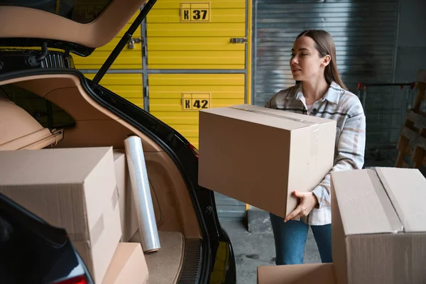 Saubere Frau Steckt Eine Kiste Mit Waren Den Kofferraum Eines — Stockfoto