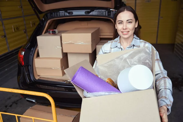 Pleasant Woman Staying Car Trunk Warehouse Holding Cardboard Box Stuff — Stock Photo, Image
