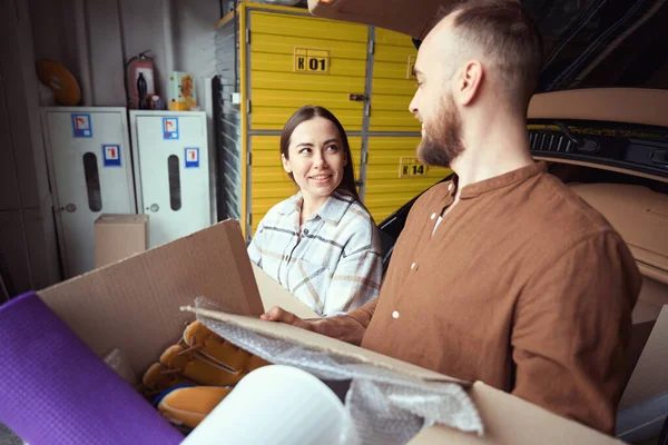 Smiling Woman Looking Grown Man Box His Hands Car Warehouse — Stock Photo, Image