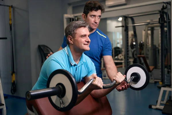 Smiling Mature Man Doing Barbell Curl Weight Bench Guided Gym — Stock Photo, Image