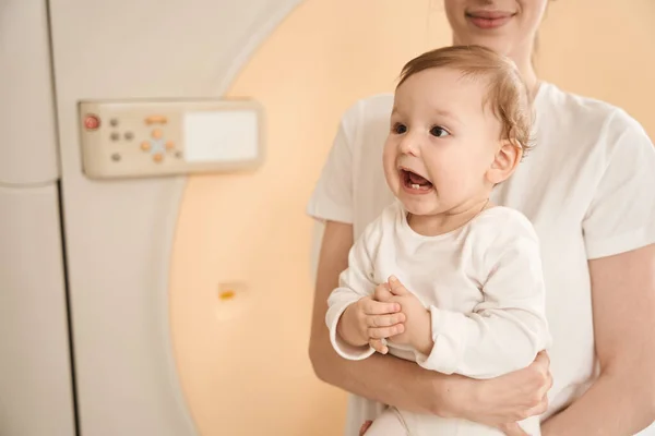 Annesinin Kollarında Bebekle Tomografi Odasında Mri Makinesinin Önünde Dikilirken Çekilmiş — Stok fotoğraf