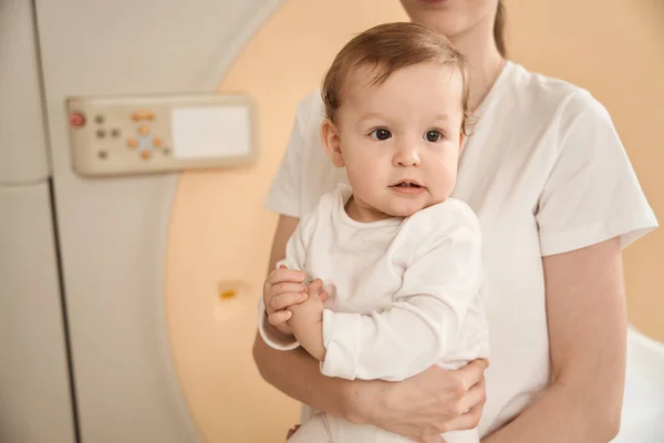 在手术室Mri扫描仪前拍摄的抱着婴儿妇女的剪影 — 图库照片