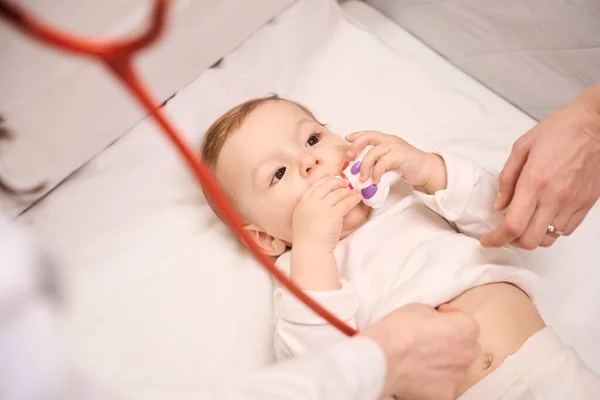 Vreedzame Pasgeboren Baby Zet Speelgoed Mond Tijdens Hart Auscultatie Uitgevoerd — Stockfoto