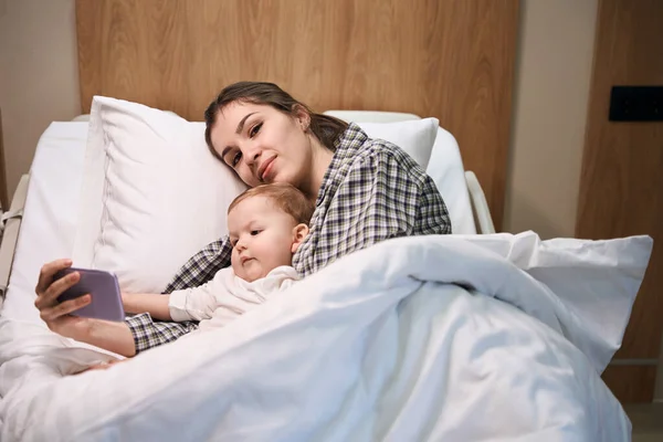 Жінка Показує Мультфільм Мобільному Телефоні Своїй Дитині Лікарняному Ліжку — стокове фото
