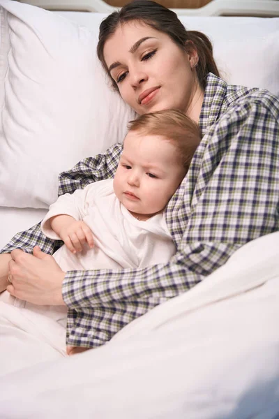 Pensive Vrouwelijke Ouder Liggend Met Haar Verdrietig Ziek Kind Bed — Stockfoto