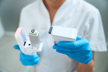 Kadın güzellik uzmanının elinde smass lift için bir modül var. Tıbbi üniformalı bir doktor.