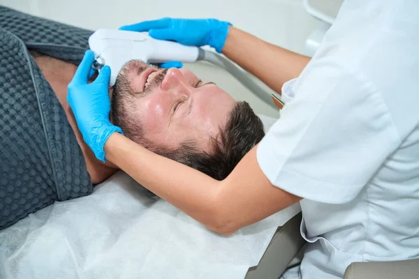 Gülümseyen Hasta Kozmetik Kanepede Uzanıyor Yenilenme Prosedüründe Güzellik Uzmanı Kitle — Stok fotoğraf
