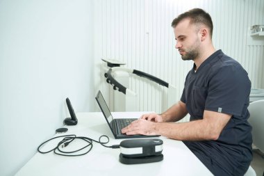 Uzman beslenme uzmanı iş yerinde dizüstü bilgisayarda, modern ekipmanlarda ofiste oturuyor.