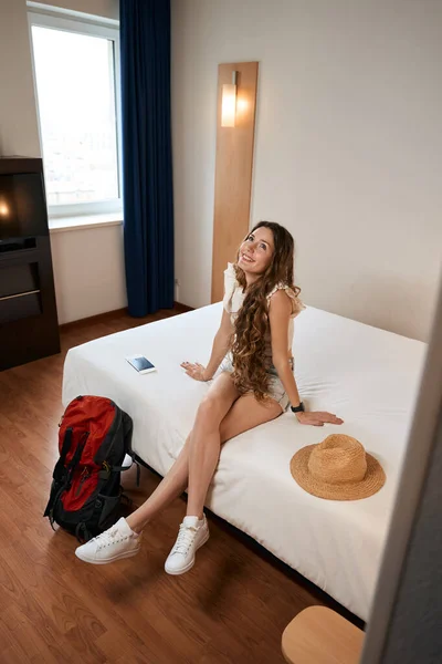 Glimlachende Vrouw Zitten Bed Buurt Van Rugzak Zoek Het Hostel — Stockfoto