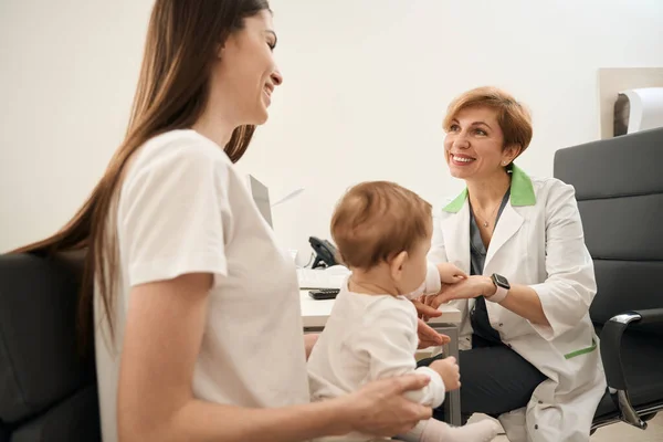 Glada Pediatriska Ögonläkare Kommunicerar Med Glad Ung Mamma Sittande Stol — Stockfoto