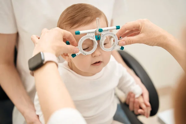 Руки Глазного Врача Ставят Офтальмологические Рамки Спокойном Маленьком Ребенке Присутствии — стоковое фото
