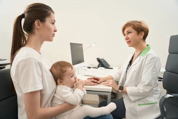 Friendly Eye Doctor Reassuring Young Woman Presence Her Infant Consultation — Stock Photo, Image