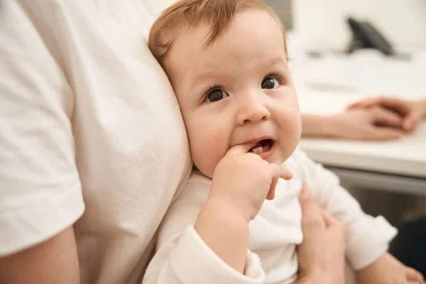 Close Bebê Sentado Colo Mãe Colocando Mão Sua Boca Aberta — Fotografia de Stock